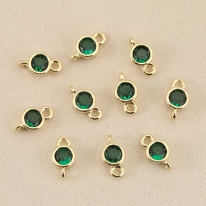 Macro view of 10-piece set of gold-plated dark green birthstone pendants for DIY jewelry
