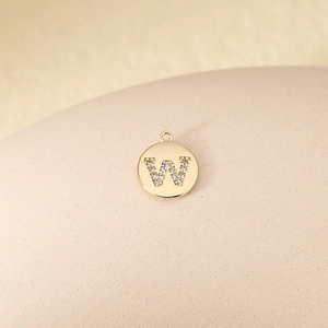 Detailed macro view of a gold-plated letter W pendant featuring sparkling cubic zirconia