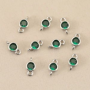 Detail of 10-piece emerald green birthstone charms with silver-plated double rings for DIY jewelry