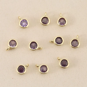 Dettaglio di ciondoli tondi con gemme viola placcati oro 18k per creazione gioielli
