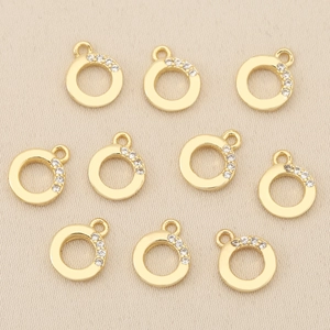 Detailed view of ten gold-plated circular pendants with zircon inlays for DIY jewelry