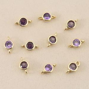 Close-up of 10 gold-plated round connectors with purple zircon for DIY jewelry making