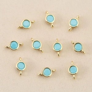 Close-up of sky blue round zircon charms with 18k gold plated double loops for DIY jewelry