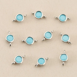 Close-up of 10 sky blue zircon round connector charms for DIY jewelry making