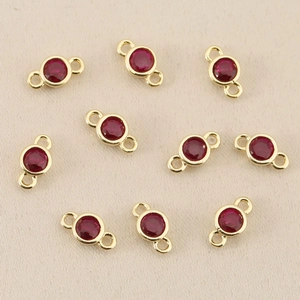 Macro detail of 18k gold plated round red zircon connectors for jewelry making