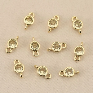 Macro shot of 18k gold plated double-loop round charms with clear yellow crystals