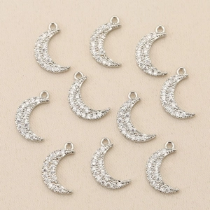 Close-up of nine 18k gold plated crescent moon charms with sparkling cubic zirconia stones