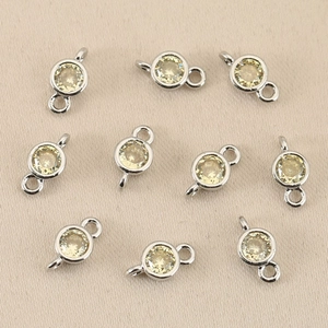 Close-up of 18k gold plated round birthstone charms for DIY jewelry making and pendants
