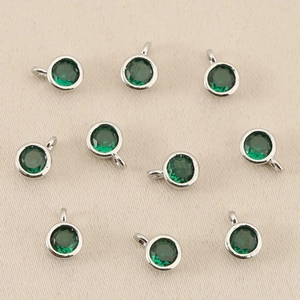 Vista macro di ciondoli rotondi placcati oro 18k con zircone verde per gioielli fai-da-te