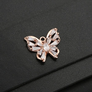 Détail macro du pendentif papillon doré rose avec zircons brillants sur cuir noir