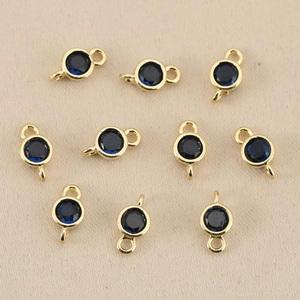 Detailed view of 10 gold-plated round dark blue birthstone connectors for DIY jewelry making