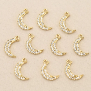 Close-up of ten gold-plated crescent moon charms with cubic zirconia for jewelry DIY