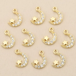 Close-up of ten 18k gold plated moon and star charms with sparkling cubic zirconia inlay