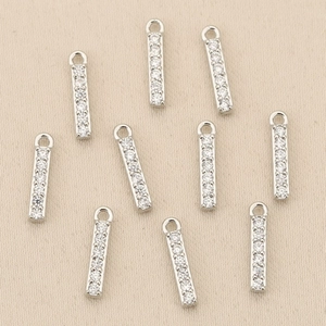 Detail view of ten silver vertical bar pendants set with cubic zirconia for jewelry making