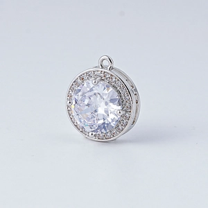 Détail d'un pendentif rond plaqué or 18k avec pavé de zircons et monture en halo argenté