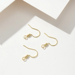 Detalle macro de ganchos para pendientes bañados en oro de 18K para joyería artesanal