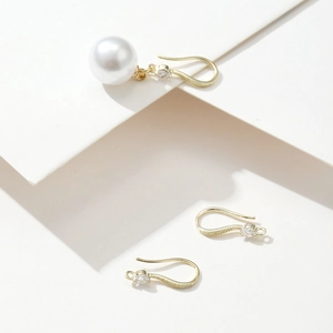 Macro detail of gold-plated copper earring hooks and white pearl DIY accessory