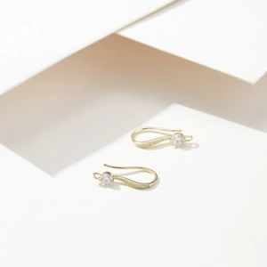 Detail of 18K gold plated copper earring hooks with zircon and mini texture finish