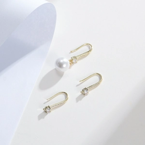 Detalle de ganchos para pendientes bañados en oro 18k con circonitas y perla blanca