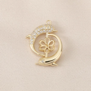 Detail of a golden dolphin jewelry pendant with sparkling zircon micro-pave and flower base