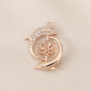 Macro shot of rose gold dolphin pendant with pave stones and pearl peg for DIY jewelry