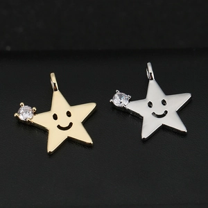 Détail des pendentifs étoiles en or 18k et argent avec smiley et zircon brillant