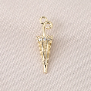 Macro detail of 18K gold plated umbrella charm with sparkling zircon for DIY jewelry
