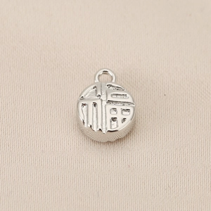 Detailed macro view of silver Chinese Fu character pendant with embossed relief design