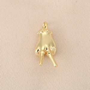Detailed view of polished 18K gold humanoid pendant accessory with closed jump ring charm