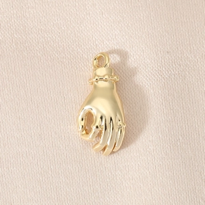Macro shot of 18K gold-plated OK gesture pendant on premium gold silk texture background