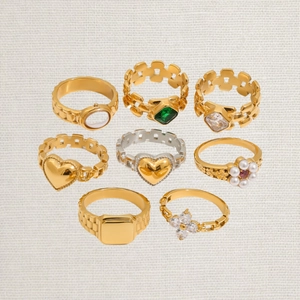 Achtteiliges Set stylischer Edelstahlringe mit Smaragd- und Perlendetails