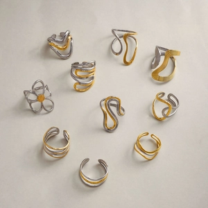 Macro shot of bicolor gold and silver stainless steel rings with irregular wavy designs