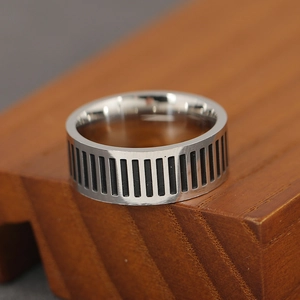 Makroaufnahme des breiten Vintage-Ringes mit schwarzen vertikalen Streifen auf Holz