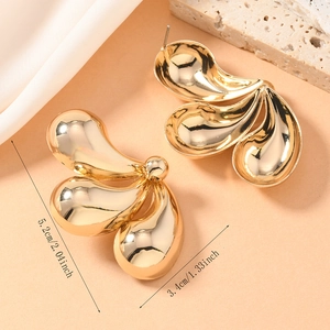 Detailansicht der goldenen Twist-Ohrringe mit Maßen 5,2 cm x 3,4 cm auf edlem Hintergrund