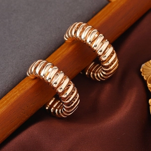 Vintage goldene klobige C-Creolen mit Spiralstruktur auf einem Holzständer präsentiert