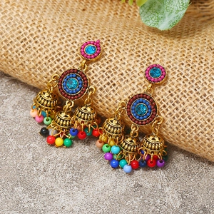 Detail of bohemian drop earrings with turquoise rhinestones and colorful hanging beads