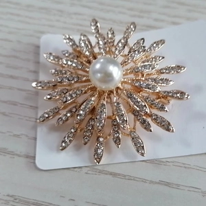 Broche tournesol dorée élégante ornée de cristaux et d'une grande perle blanche centrale