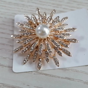 Broche fleur soleil dorée élégante avec perle centrale et accents de cristaux brillants