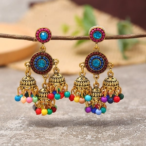 Detail of bohemian Jhumka earrings with colorful beads and turquoise rhinestones