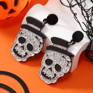 Glitterende schedel oorbellen met zwarte hoeden op oranje Halloween-thema achtergrond