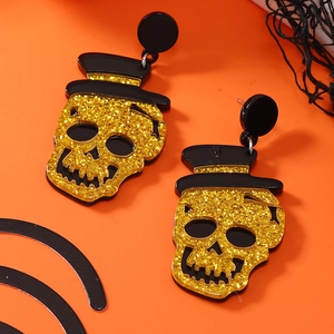 Halloween acryl oorbellen met gouden glitter schedels en zwarte hoeden op een oranje achtergrond