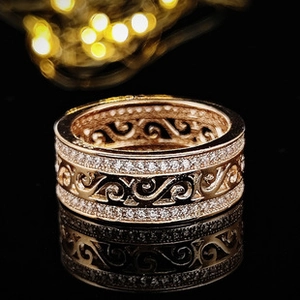 Vista detallada de anillo ancho calado en oro rosa con incrustaciones de circonitas