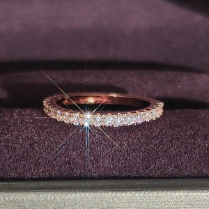 Macro view of rose gold eternity band with pavé set diamonds in purple velvet box