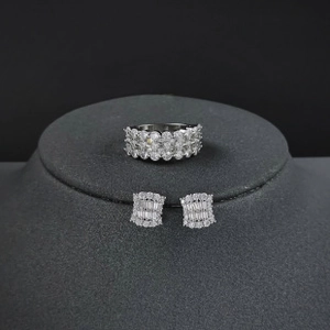 Macro detail of silver jewelry set with zircon crystals on a dark velvet display