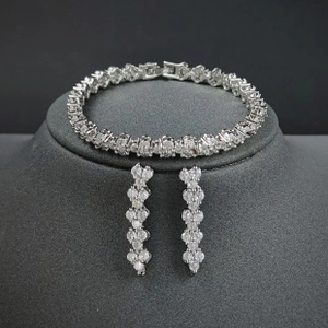 Detailed view of silver jewelry set featuring sparkling zircon bracelet and drop earrings