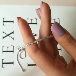 Bracciale minimalista in argento con cristalli di zircone su un polso femminile