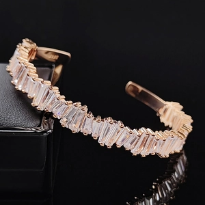 Macro detail of rose gold open bracelet with baguette-cut stones and S925 hallmark
