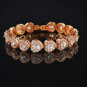 Golden heart link tennis bracelet featuring clear heart stones and micro-pave crystals