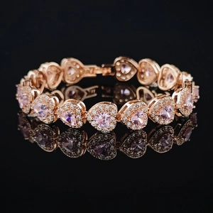 Elegant rose gold tennis bracelet featuring pink heart-shaped crystals on mirror surface