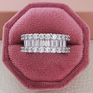 Macro view of wide silver eternity ring with three rows of baguette and round cut zircons